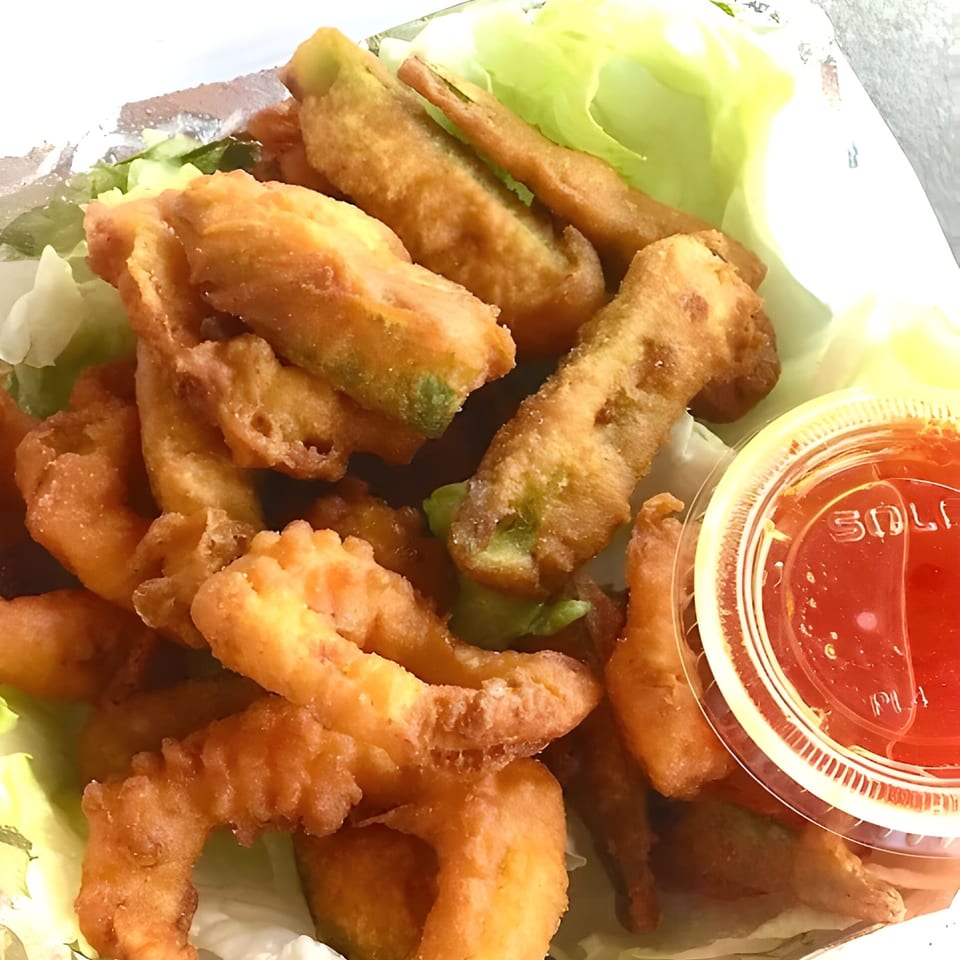 Crispy fried Thai Wok ToGo appetizers, possibly vegetables or shrimp, served with a side of sweet chili sauce.